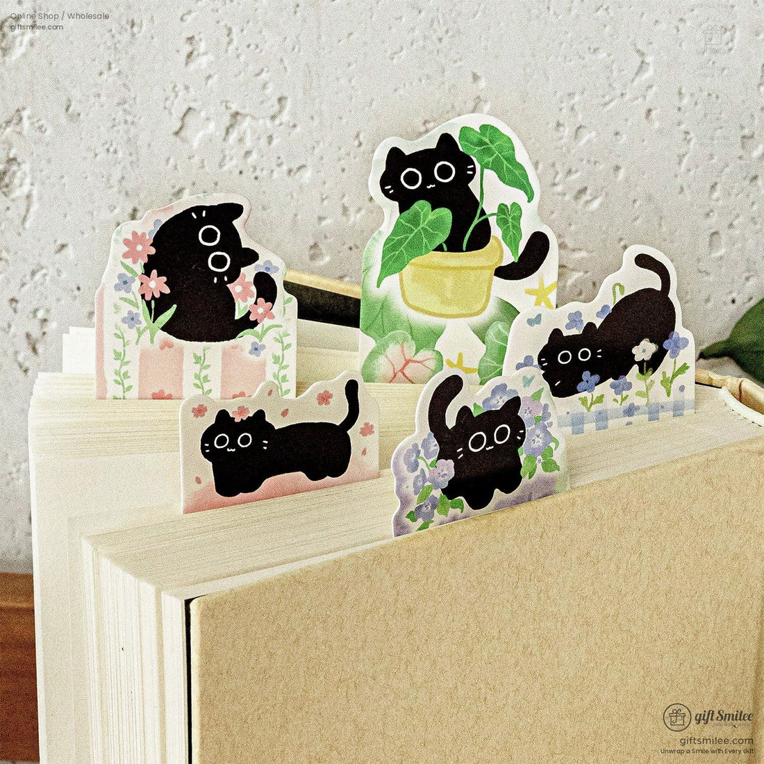 Cute black cat sticky bookmarks peeking from a book – floral plant theme