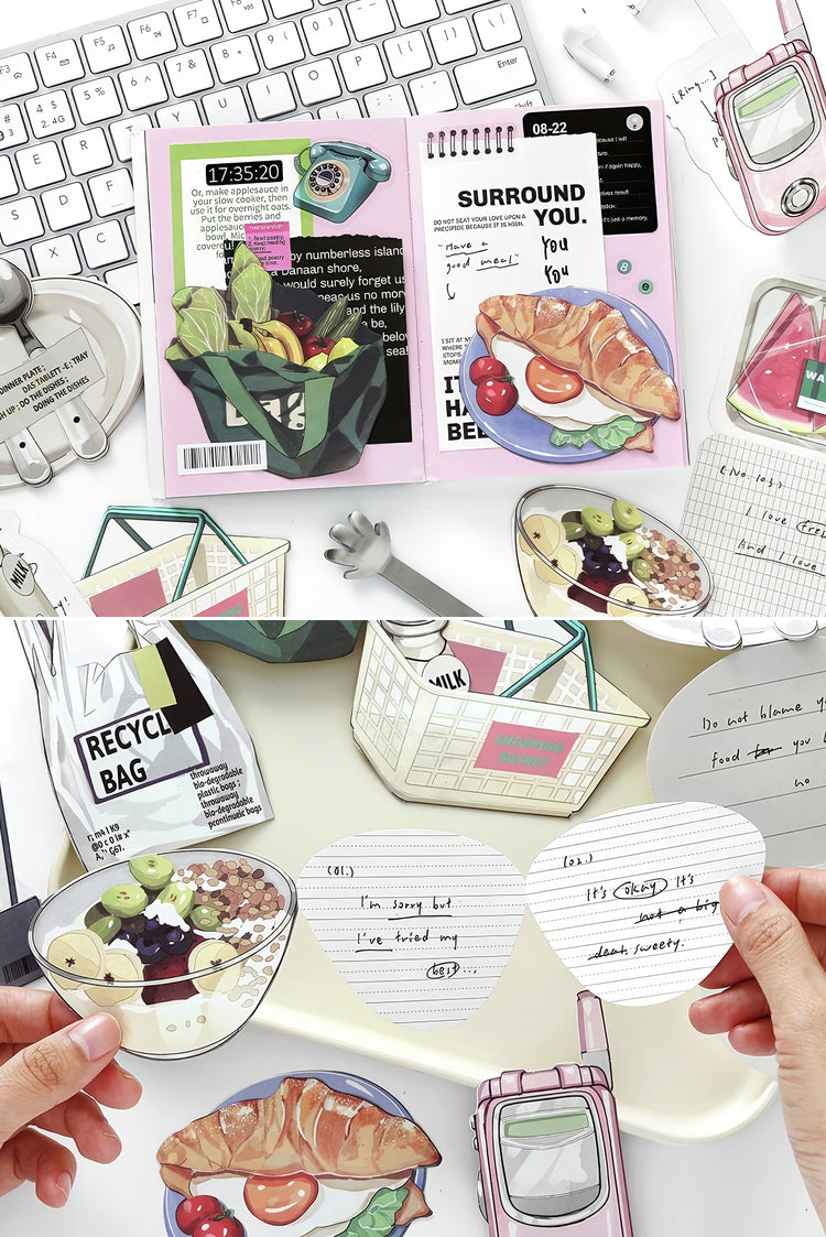 Assorted foodthemed stickers with croissant salad and fruit designs on pastel stationery and a white keyboard