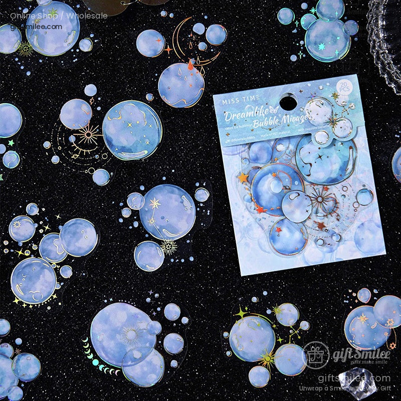 Close-up of celestial-themed blue holographic bubble stickers scattered on a sparkling black background