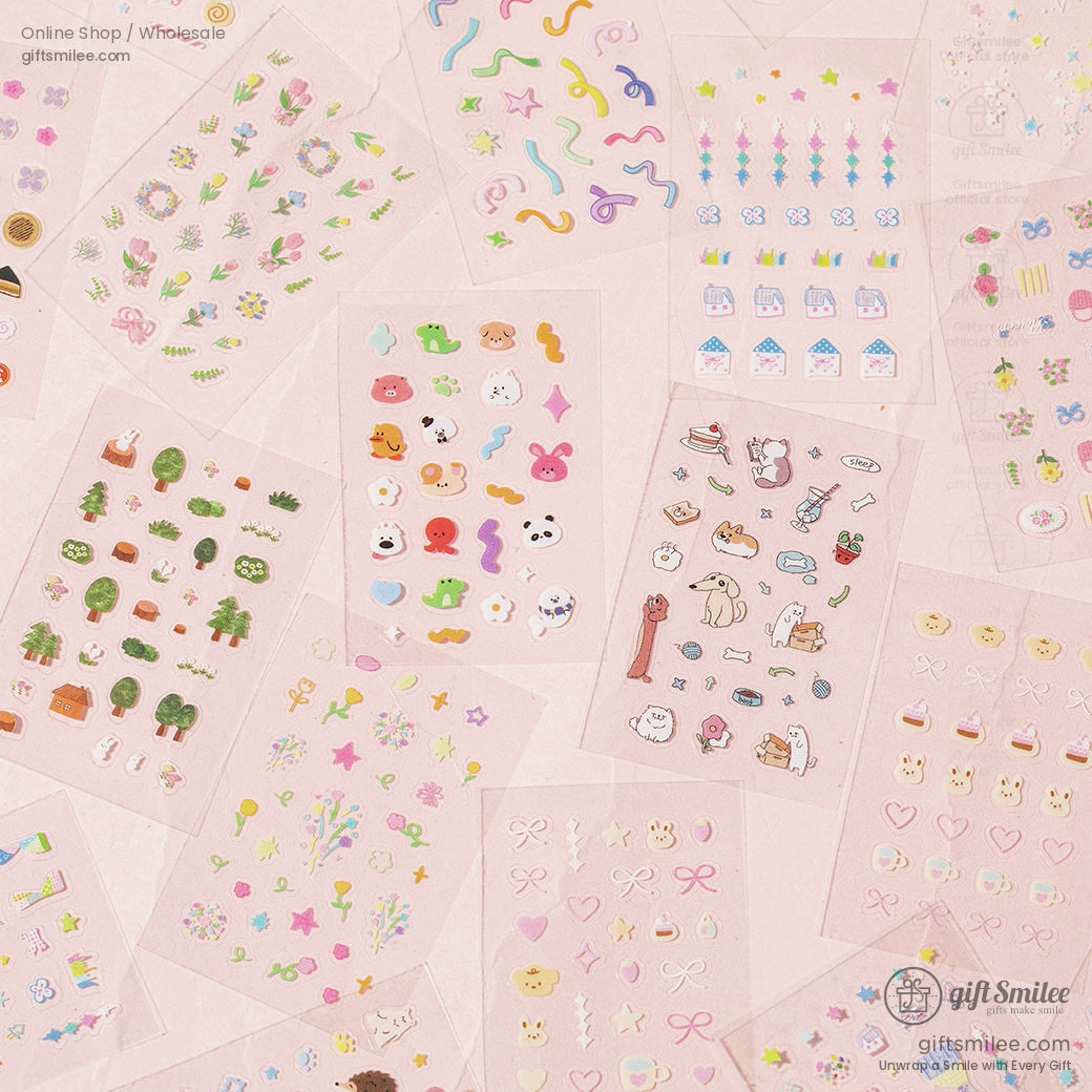 A close-up of various sticker designs including animals, bows, and pastel shapes spread out on a pink background