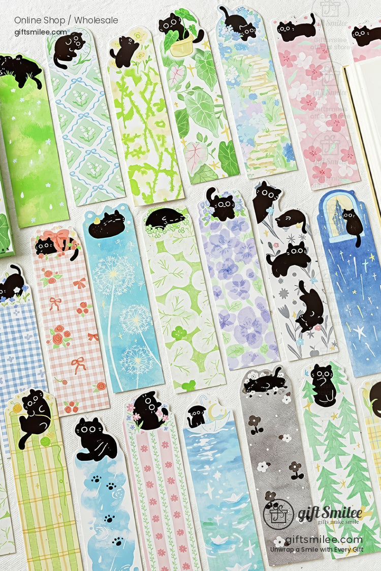 Cute black cat bookmarks with floral and pastel patterns displayed on a desk