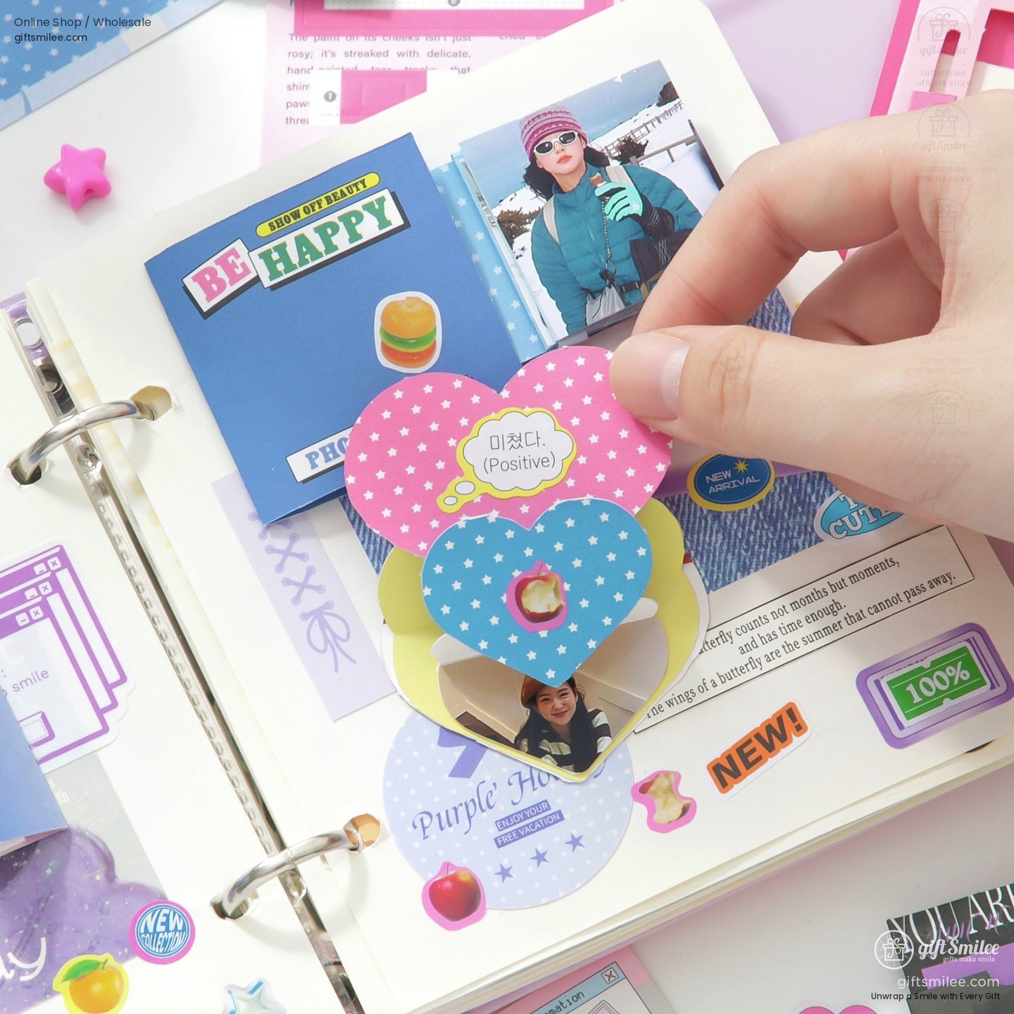 DIY scrapbook kit with colorful stickers, envelopes, and paper craft supplies laid out on a white desk