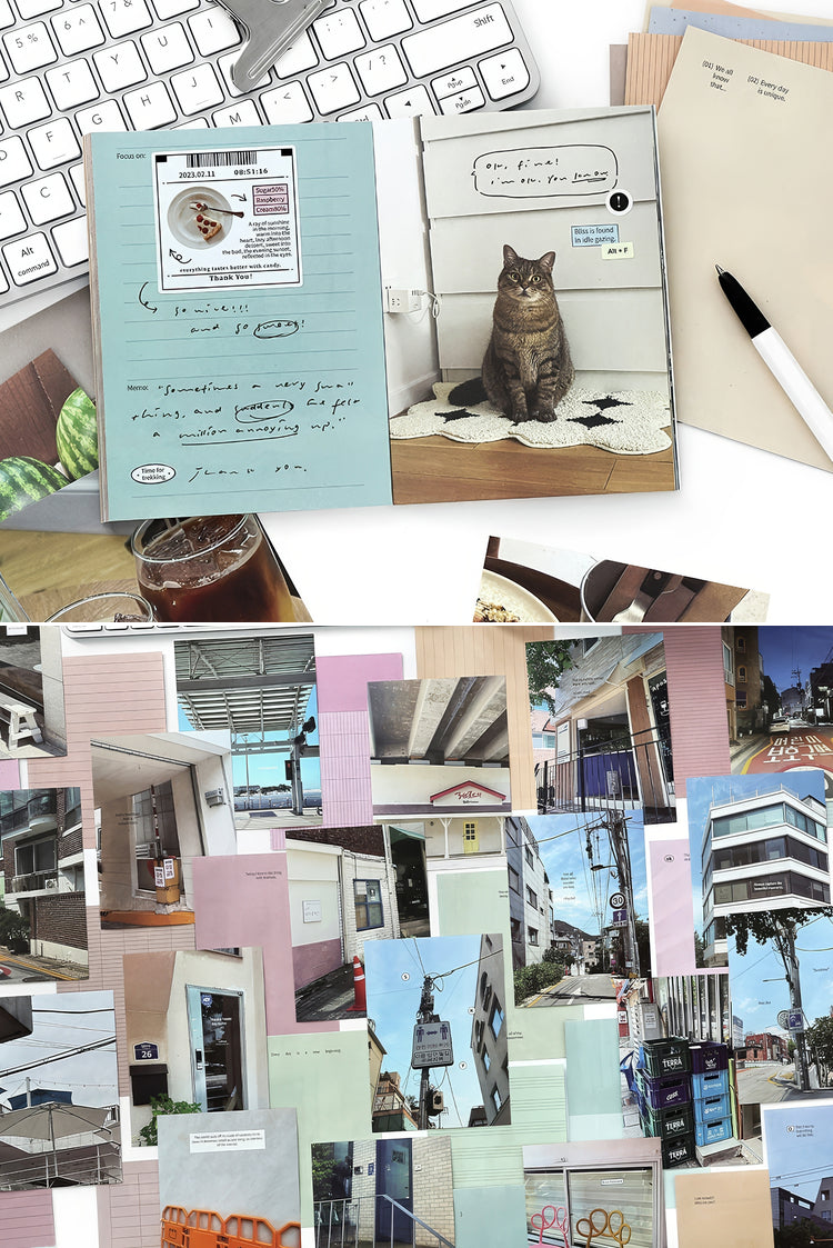 Open journal with pastel blue pages cat illustration handwritten notes and scattered urban photo prints on a desk