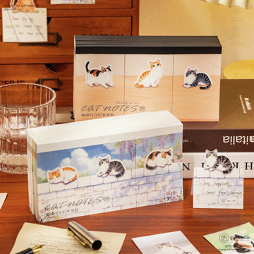 Decorative catthemed sticky notes in pastel designs featuring playful kittens against wood and floral backgrounds