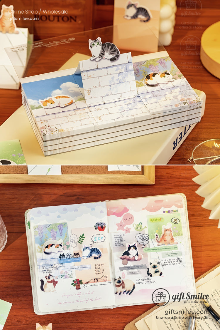 Stack of pastelcolored stationery with cat illustrations including popup designs and a journal with playful cat stickers