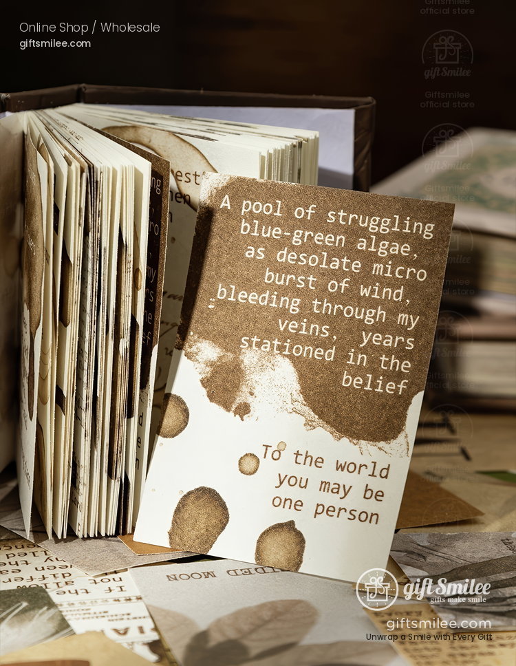 Vintagestyle brown and cream card with poetic text abstract ink splashes and an open rustic journal in the background