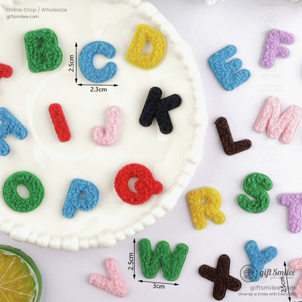 Multicolored crochet alphabet letters of 25 cm size on white ceramic plate featuring vibrant textures and playful design