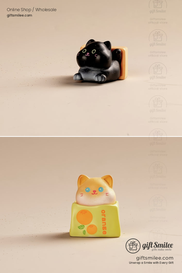 Black cat figurine resting on a toastshaped base and orange tabby cat figurine atop a yelloworange juice carton