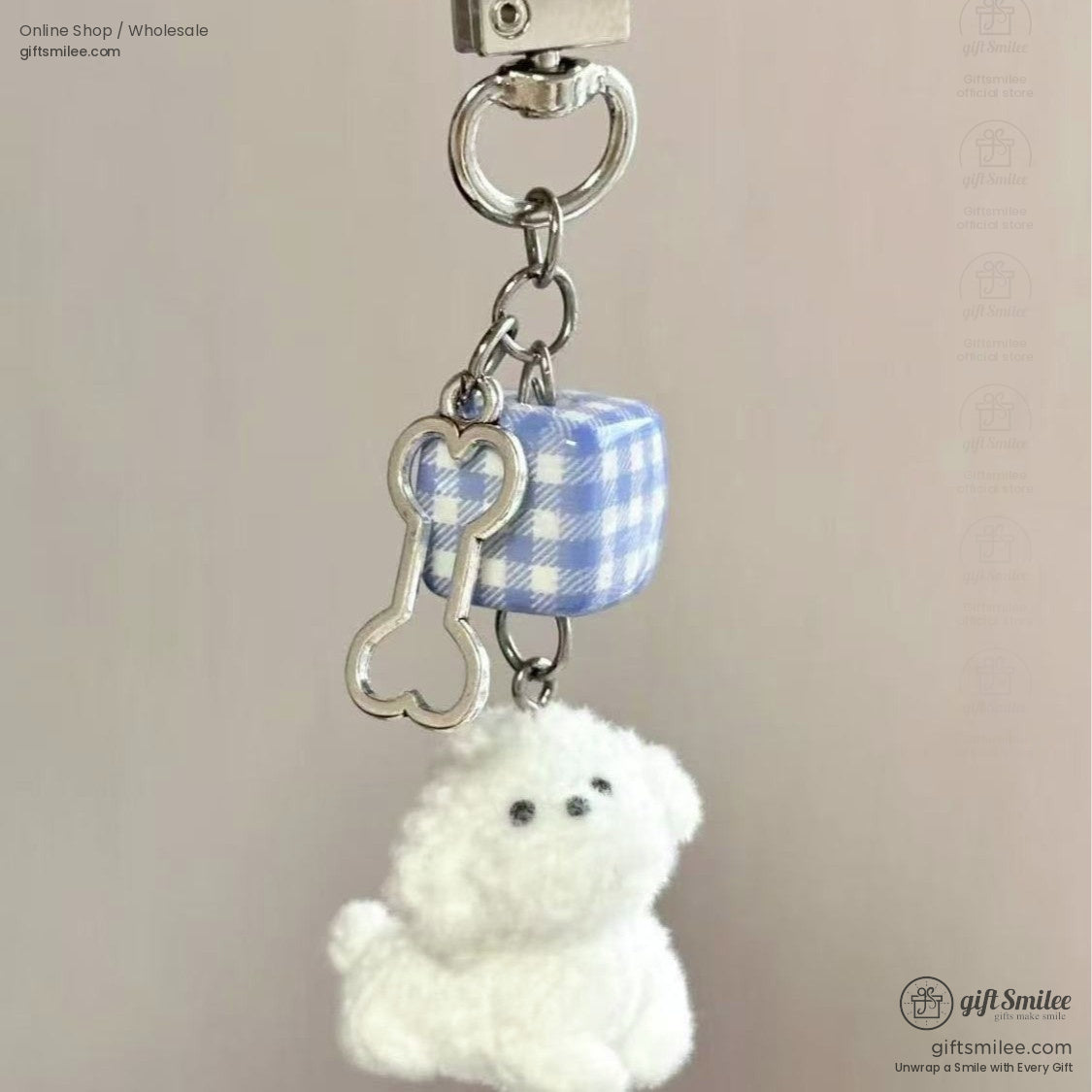 Fluffy white dog keychain with silver bone charm and blue gingham cube accent on a metallic clasp ring