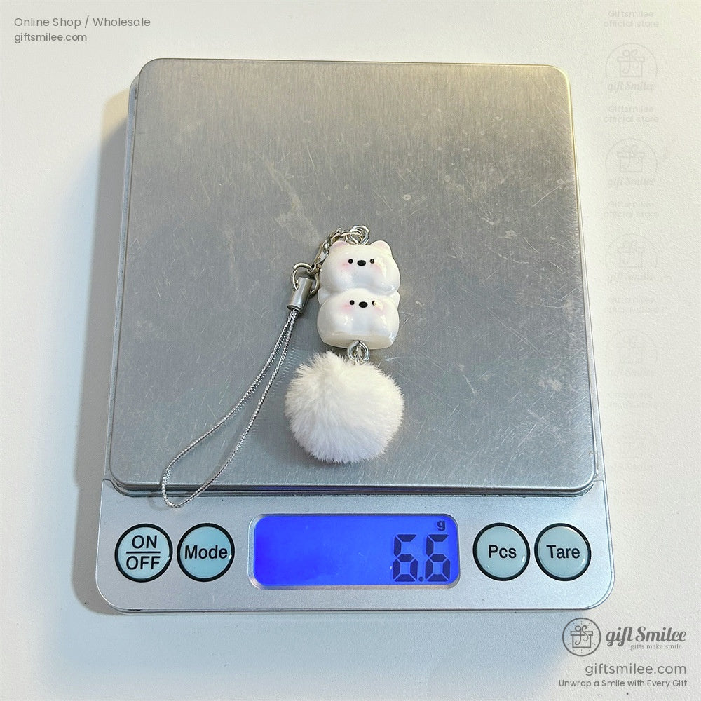 White ceramic bear charm with pink accents fluffy pompom silver strap displayed on a digital scale reading 66g