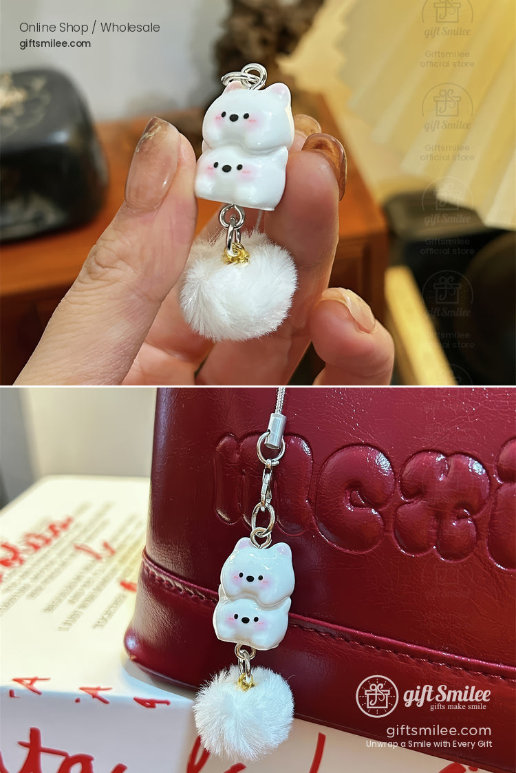 White ceramic bear charm with black facial details gold accent and soft fluffy pompom attached to a silver clasp