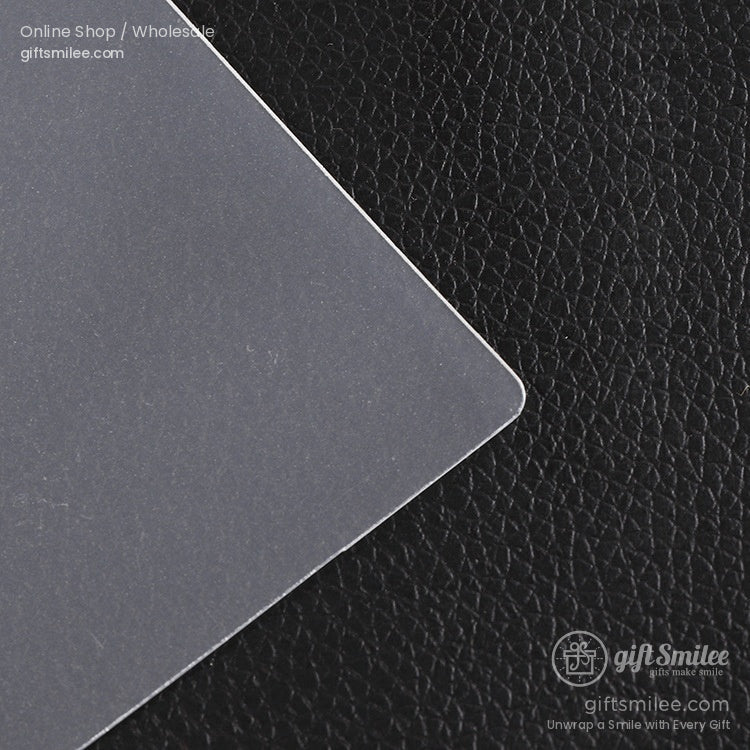 Frosted transparent plastic sheet with a smooth matte finish placed on textured black leather surface