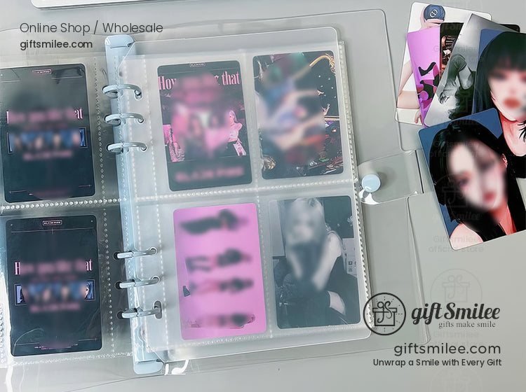 Clear plastic photo album with multiple pockets holding colorful Kpop photocards and additional cards scattered nearby