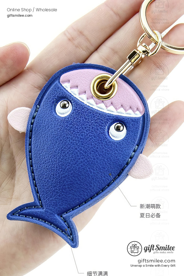 Blue leather fishshaped keychain with pink fin accents stitched details goldtone clip and playful design