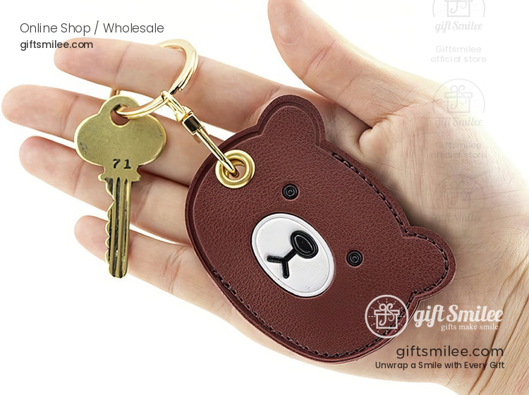 Brown bearshaped leather keychain with gold keyring black stitched details and adorable cartoon face design