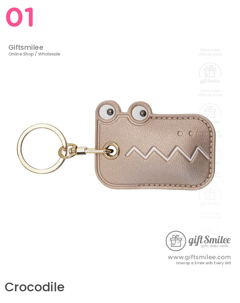Metallic gold crocodileshaped leather keychain with googly eyes zigzag white detailing and goldtone keyring