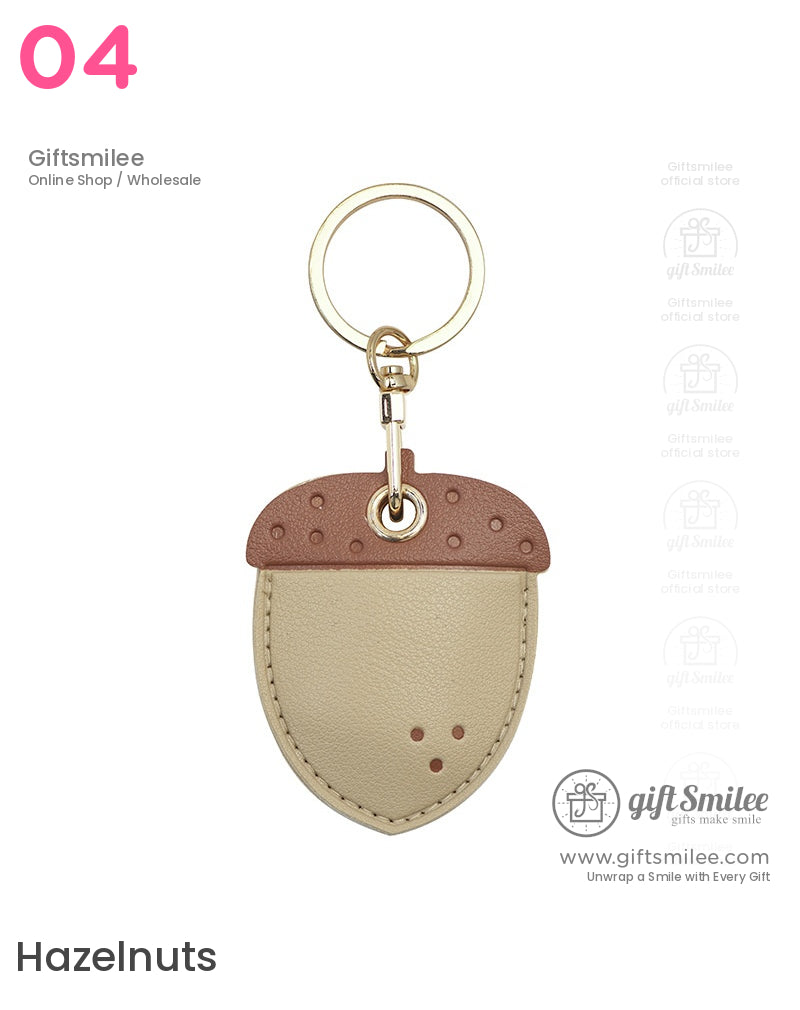 Tan and brown acornshaped leather keychain with goldtone ring and clasp featuring fine stitching details