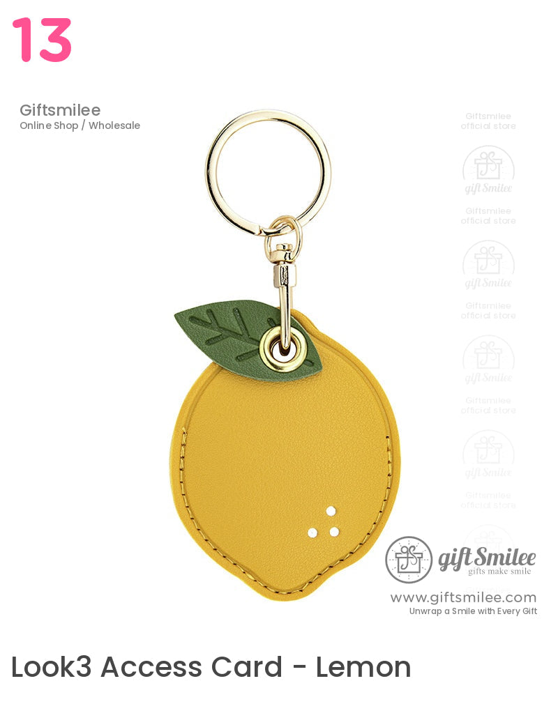 Yellow faux leather lemonshaped keychain with green leaf accent and goldtone metal ring clasp