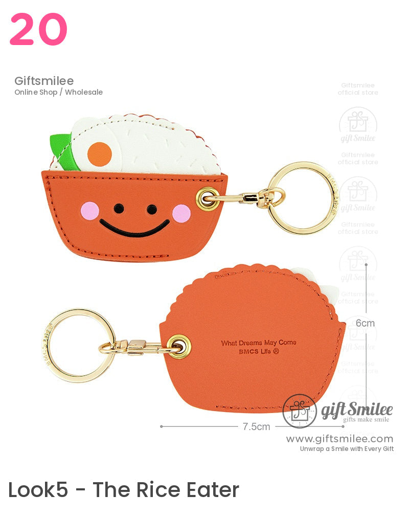 Orange faux leather keychain shaped like a smiling rice bowl with goldtone ring white rice and green garnish detail