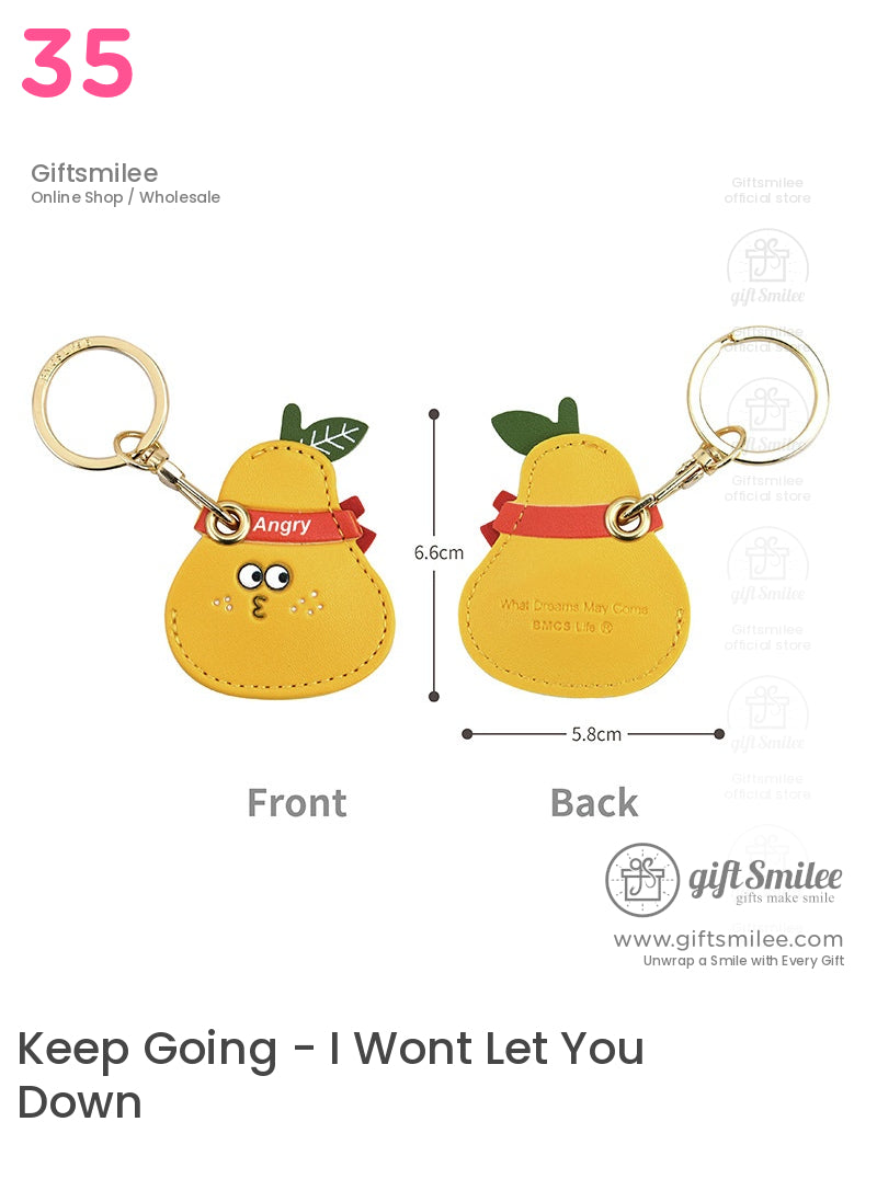 Yellow pearshaped faux leather keychain with green leaf accents red bow detail gold ring and playful cartoon face
