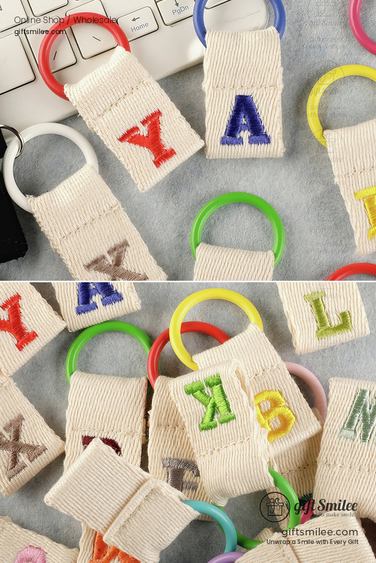 Beige cotton keychains with colorful embroidered letters and vibrant plastic rings in red blue green and yellow