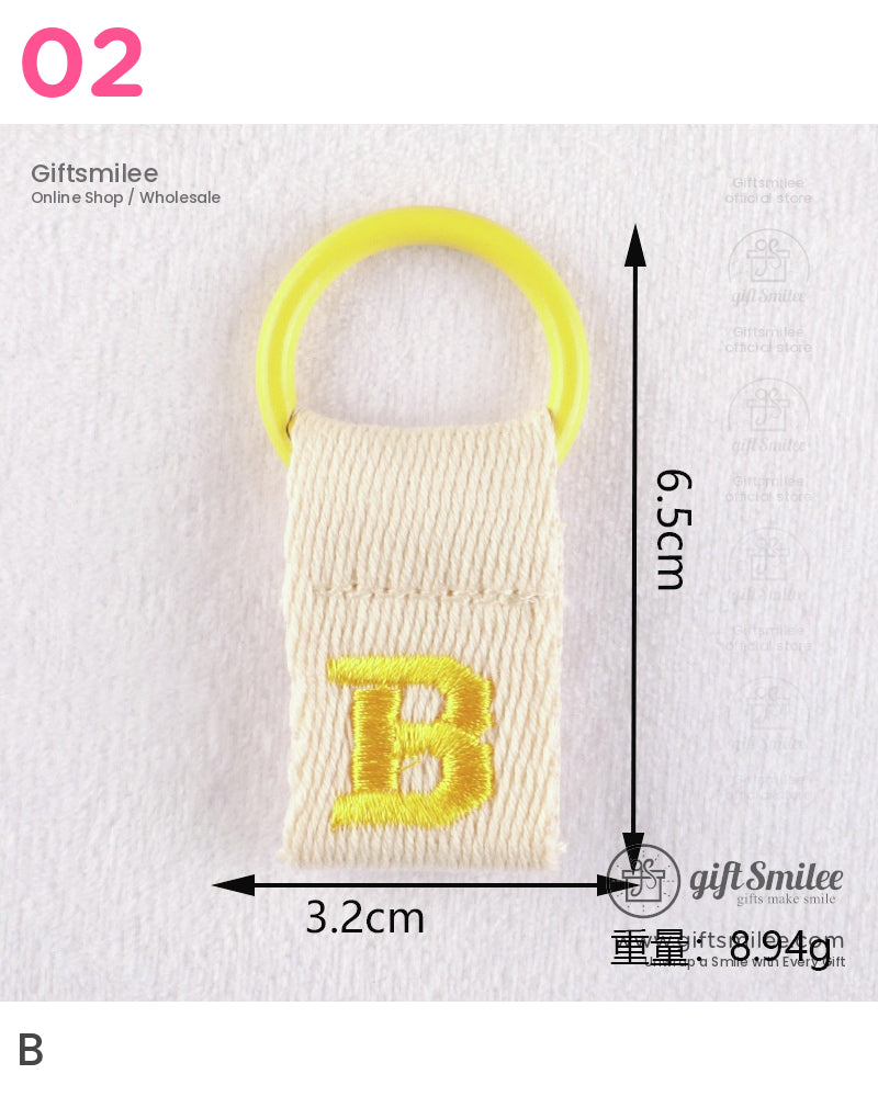 Beige cotton keychain with yellow embroidered B and bright yellow plastic ring measuring 65cm by 32cm