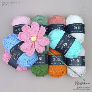 Assorted pastel milk cotton yarn in pink blue green orange and white with a handmade pink knitted flower