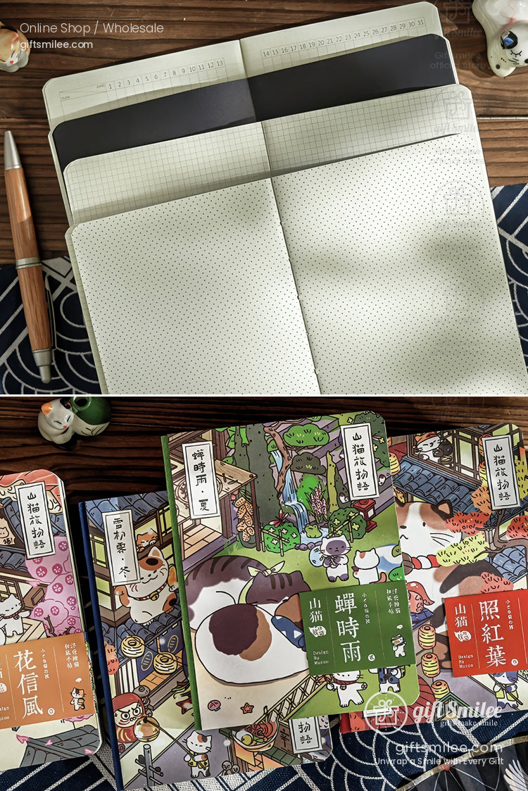 Open cream dotgrid notebook with a brown pen and vibrant Japanesestyle illustrated books on a wooden surface