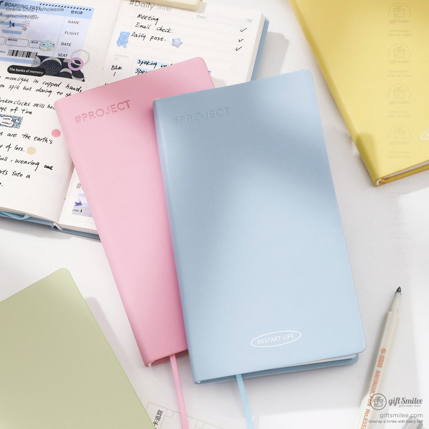 Pastel project planners – light blue and pink hardcover notebooks with bookmarks on a desk, ideal for daily planning and journaling.