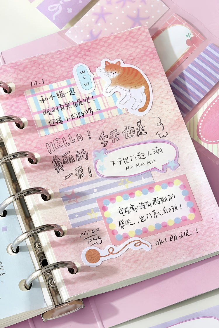 Pink spiralbound planner with pastel doodles cat sticker striped washi tape accents and colorful handwritten notes