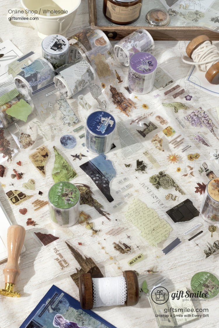 Decorative washi tapes with floral vintage and nature designs scattered on a white wooden table with crafting tools