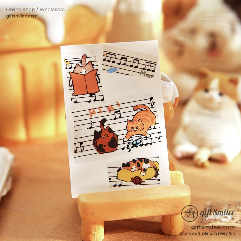 Transparent sticker sheet with playful cat illustrations on musical notes featuring orange black and calico designs