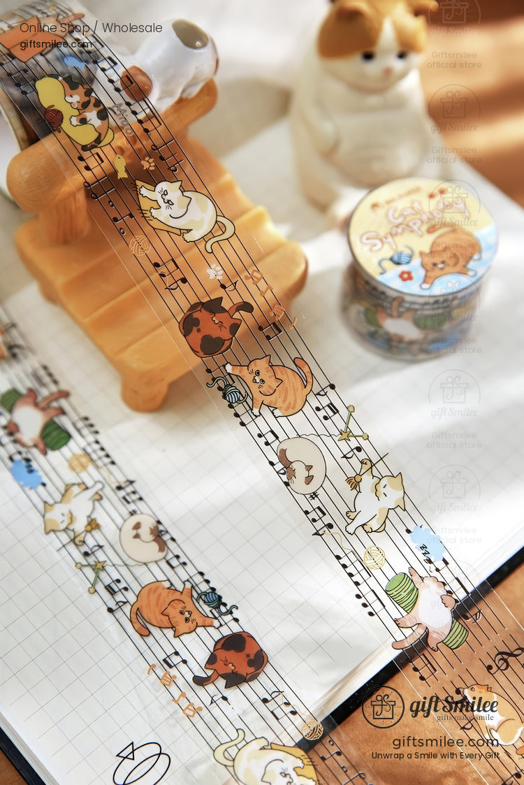 Transparent washi tape with playful cat illustrations on a musical staff paired with a matching decorative roll