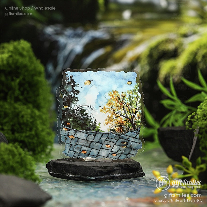 A nature-themed watercolor sticker featuring a serene puddle reflecting autumn trees and a bright sky