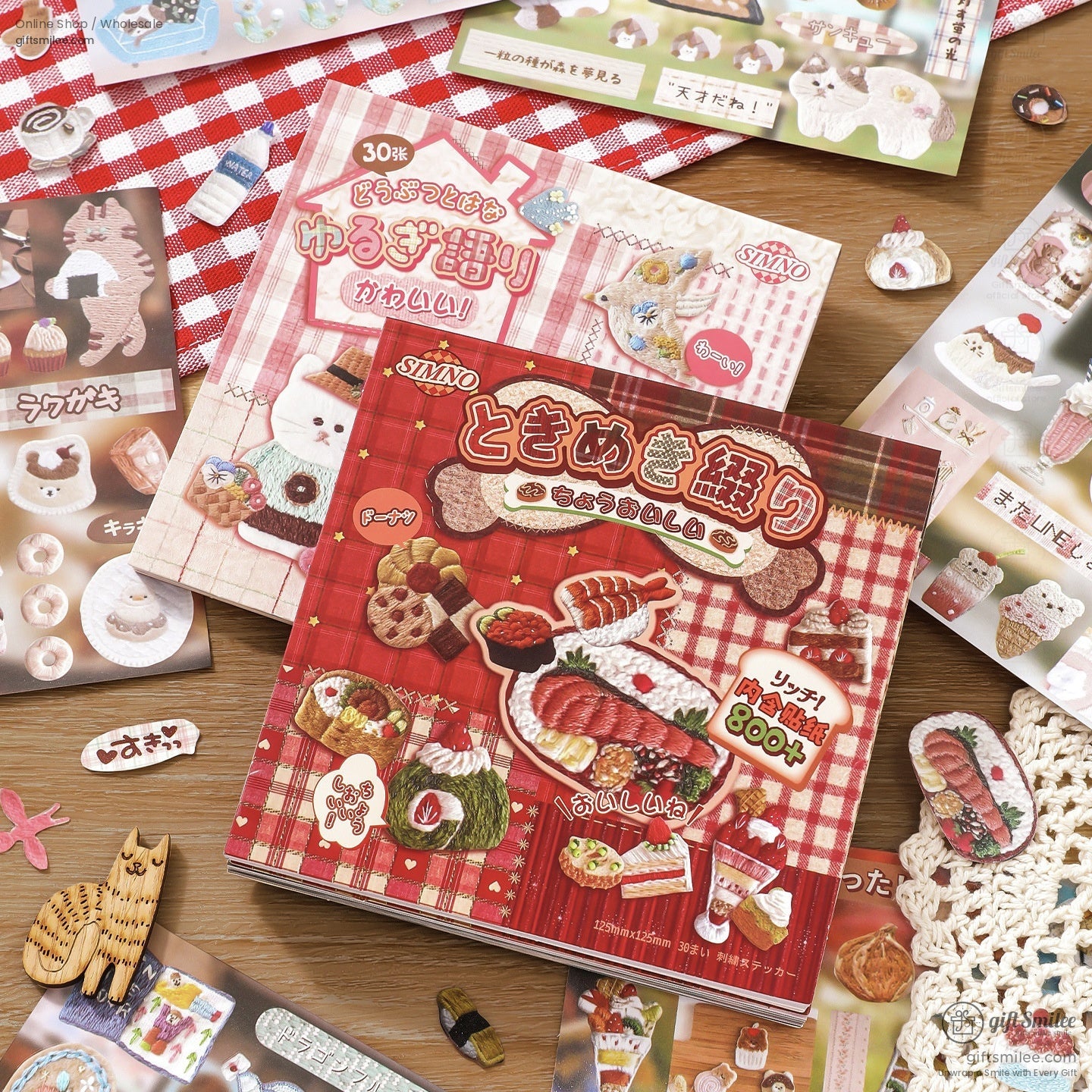 Japanese embroidery sticker book with food and animal designs on a rustic picnic tablecloth