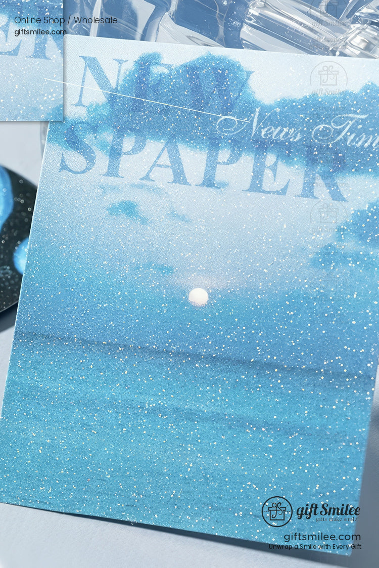Glittery blue postcard with ocean waves moonlit sky and white Newspaper text in elegant font