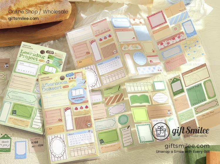 Assorted pastel stationery stickers with frames labels and patterns in green pink and beige on a light table