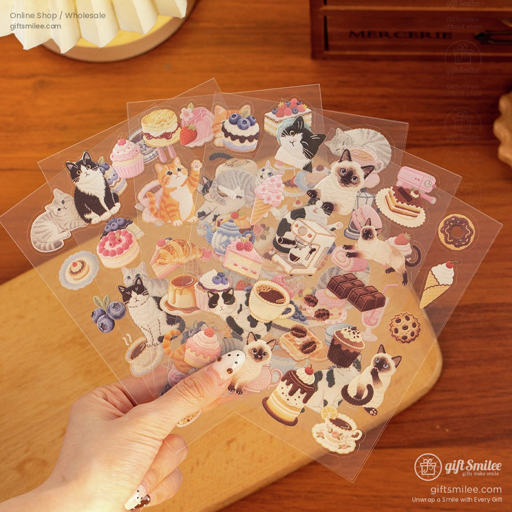 Transparent sticker sheets with colorful cat illustrations pastries desserts and coffee designs on a wooden surface