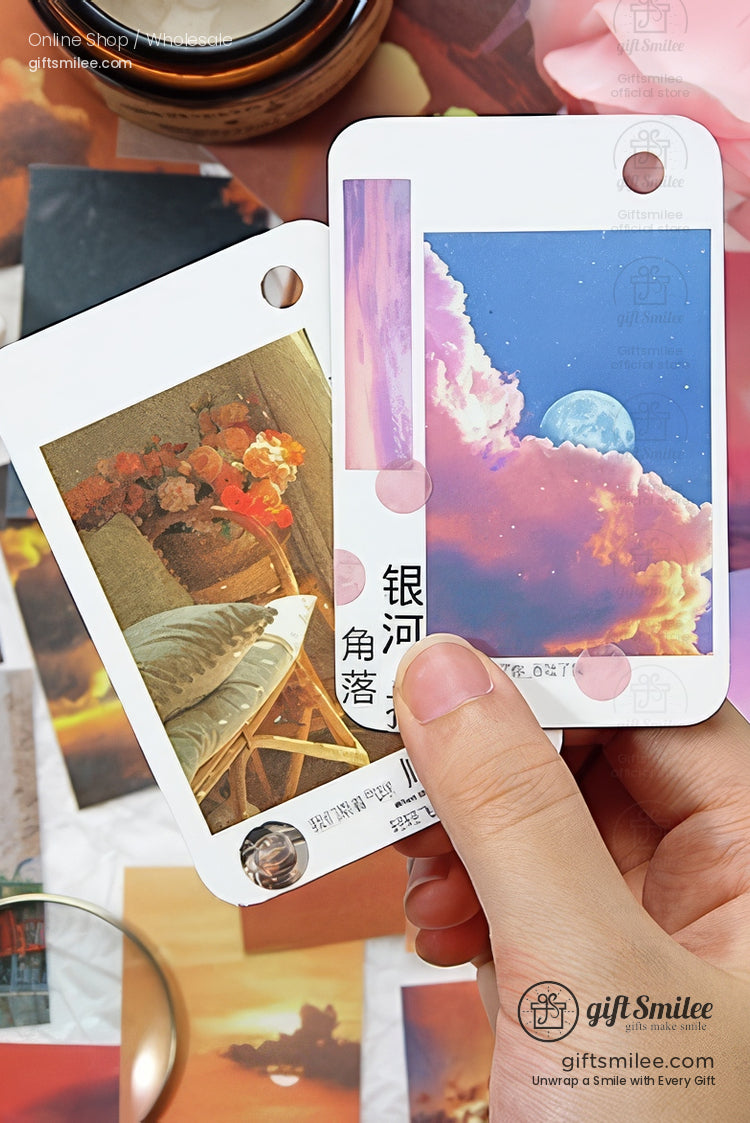 Hand holding aesthetic art prints with dreamy pastel cloud and moon design alongside floral stilllife illustration