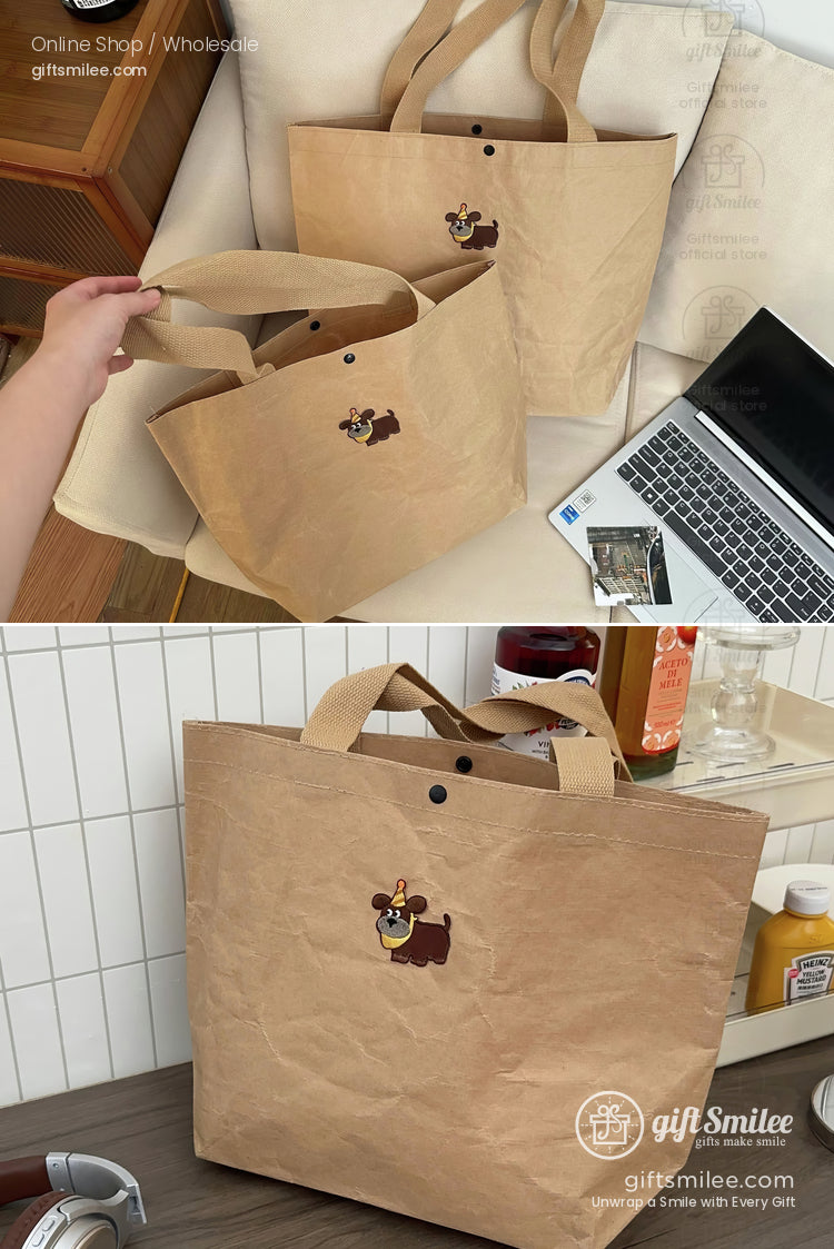 Light brown papertextured tote bag with small cartoon dog embroidery snap button closure and sturdy fabric handles