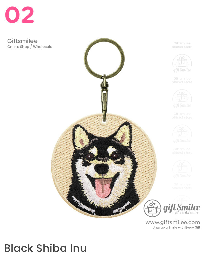 Round beige fabric keychain with embroidered black and tan Shiba Inu face pink tongue and antique brass keyring