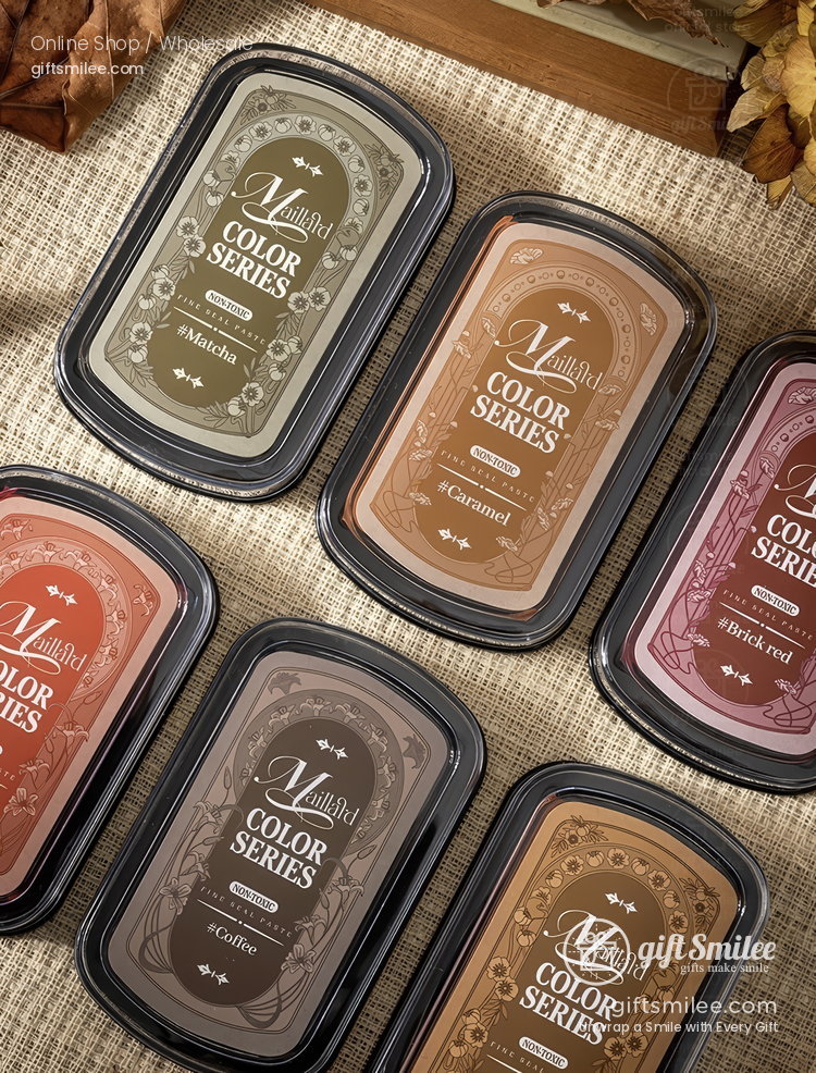 Assorted beige brown and muted red ink pads in rectangular black cases with ornate vintagestyle labels