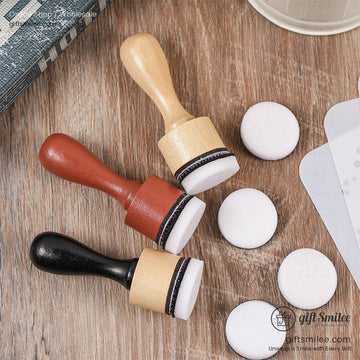 Set of three foam blending brushes with wooden handles in natural red and black finishes on a wooden surface