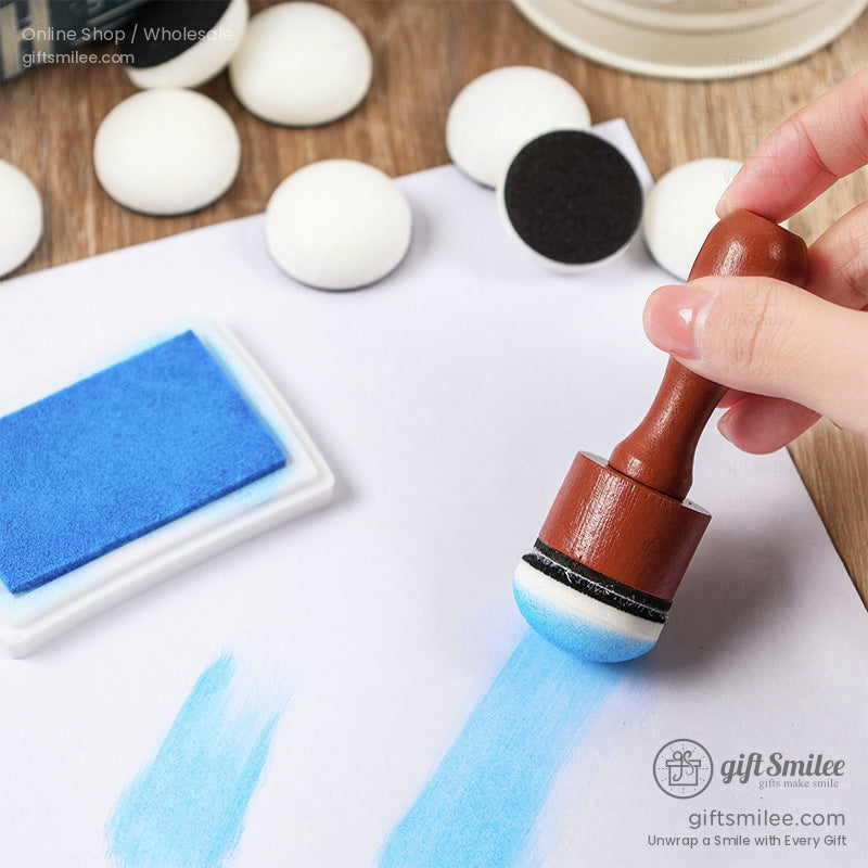 Brown wooden dauber handle with a blue foam sponge tip used with a rectangular blue ink pad on white paper